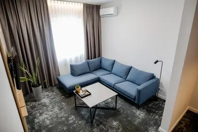 a living room with a blue couch and a table at Hotel Tomas in Šiauliai