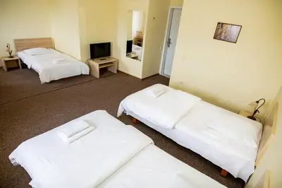 a hotel room with two beds and a television at Hotel Tomas in Šiauliai