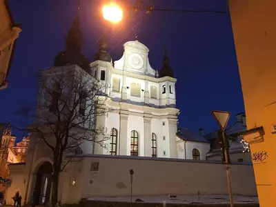 a white building with a clock tower at night at Cozy Apt in the Heart of Old Town in Vilnius