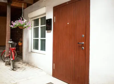 a bike parked next to a house with a wooden door at Cozy Apt in the Heart of Old Town in Vilnius
