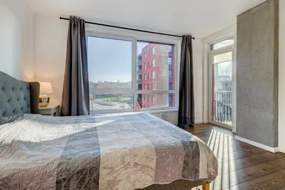 a bedroom with a bed and a large window at Five Star Downtown Apartment in Vilnius