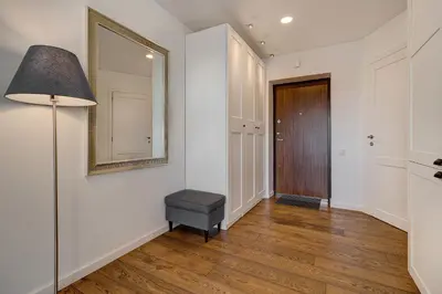 a hallway with a table and a mirror and a door at Five Star Downtown Apartment in Vilnius
