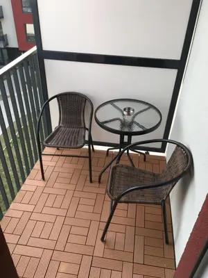 two chairs and a glass table on a balcony at Five Star Downtown Apartment in Vilnius