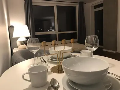 a table with a bowl and wine glasses on it at Five Star Downtown Apartment in Vilnius