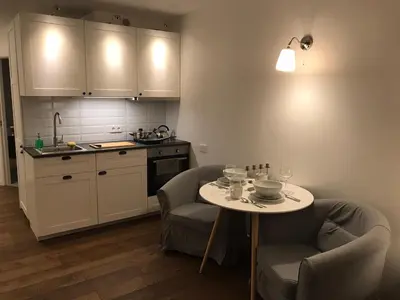 a kitchen with a table and two chairs and a kitchen with a counter at Five Star Downtown Apartment in Vilnius