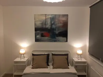 a bedroom with a bed with two nightstands and two lamps at Elegant apartment close to the Old Town in Vilnius