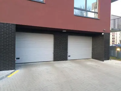 two garage doors on the side of a building at Elegant apartment close to the Old Town in Vilnius