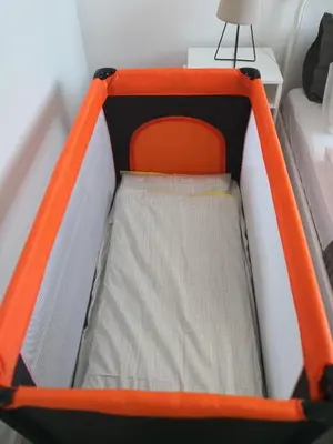 an orange and white childs bed with an orange and white mattress at Elegant apartment close to the Old Town in Vilnius