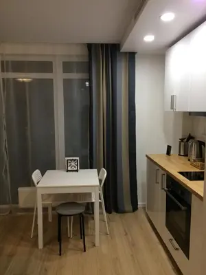 a small kitchen with a white table and chairs at Elegant apartment close to the Old Town in Vilnius
