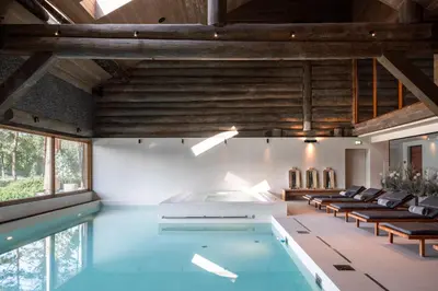 a swimming pool in a house with chairs around it at Esperanza Lake Resort, a Member of Design Hotels in Trakai