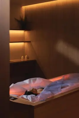 a woman laying on a bed in a bedroom at Esperanza Lake Resort, a Member of Design Hotels in Trakai