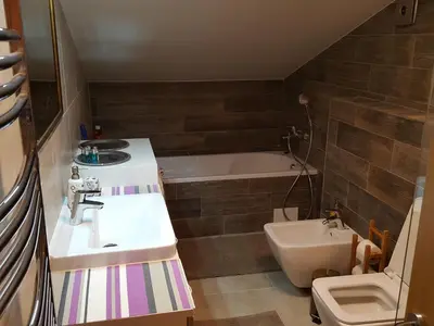 a bathroom with a sink and a tub and a toilet at City Dawn Gate Apartment in Vilnius
