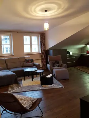 a living room with a couch and a table at City Dawn Gate Apartment in Vilnius