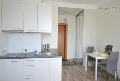 a kitchen with white cabinets and a table and a sink at Vilnius Town Apartments in Vilnius
