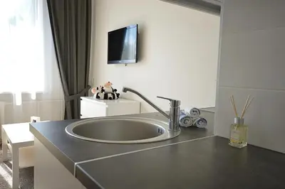a bathroom with a sink and a tv on the wall at Vilnius Town Apartments in Vilnius