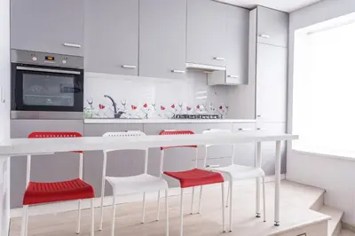 a kitchen with white cabinets and red stools at Sandra apartamentai in Kaunas