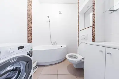 a bathroom with a tub and a toilet and a sink at Sandra apartamentai in Kaunas