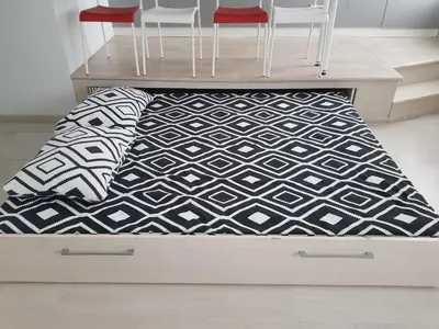 a bed with a black and white rug in a room at Sandra apartamentai in Kaunas