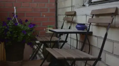 two chairs and a table with a blue vase on it at Nature lovers place in Varėna