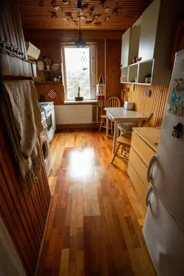a kitchen with a wooden floor and a table and a window at Nature lovers place in Varėna