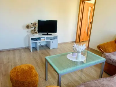 a living room with a tv and a coffee table at Ezero apartamentai in Šiauliai