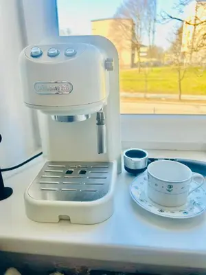 a mixer sitting on a counter next to a cup at Ezero apartamentai in Šiauliai