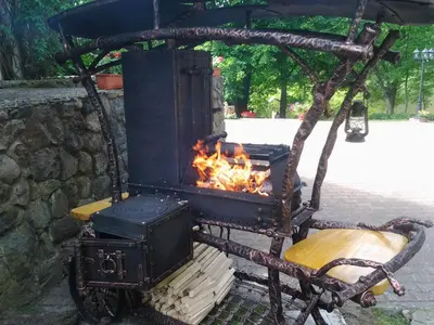 an old wood stove with a fire in it at Senieji Bačkonys in Bačkonys