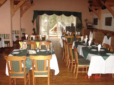 a dining room with tables with green and white tablecloths at Senieji Bačkonys in Bačkonys