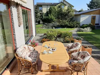 a wooden table and chairs on a patio at Apartamentai Luna in Panevėžys