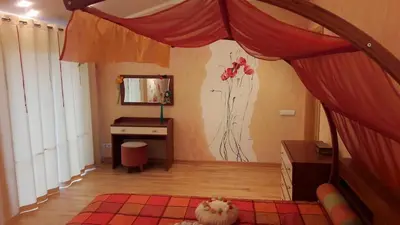 a bedroom with a bed with a desk and a mirror at Apartamentai Luna in Panevėžys