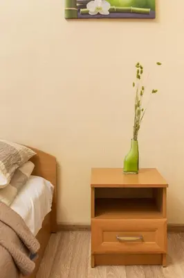 a table with a green vase on top of a bed at Pigi nakvyne in Šiauliai