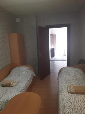 a room with two beds and a door with a window at Ginto svetingi namai in Vilnius