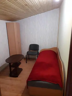 a room with a bed and a chair and a table at Ginto svetingi namai in Vilnius