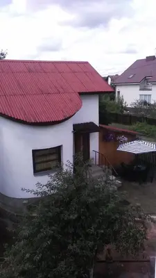 a white house with a red roof at Ginto svetingi namai in Vilnius