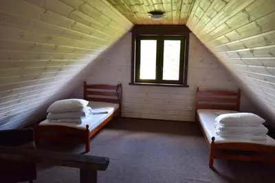 a attic room with two beds and a window at Trakų vienkiemis in Daumilai