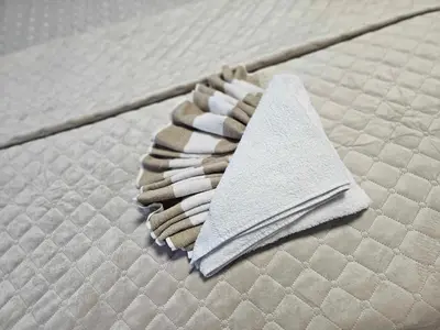 a white napkin sitting on top of a mattress at Apartamentai Druskininku centre in Druskininkai