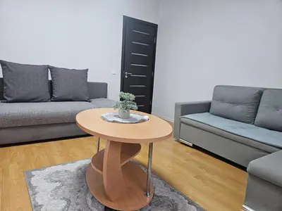 a living room with a table and a couch at Apartamentai Druskininku centre in Druskininkai