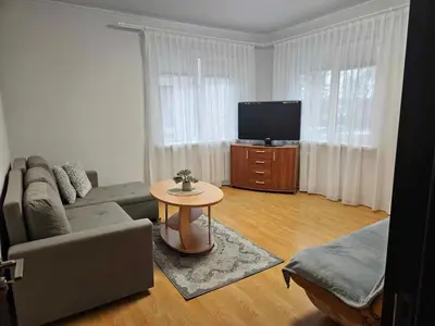 a living room with a couch and a tv at Apartamentai Druskininku centre in Druskininkai