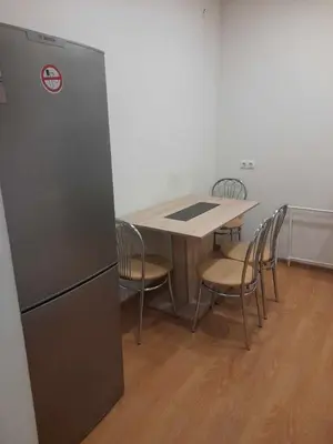 a kitchen with a table and chairs and a refrigerator at Apartamentai Druskininku centre in Druskininkai