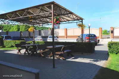 a picnic table and benches under a pavilion at Olympus Hotel in Kaunas