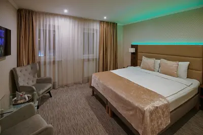 a hotel room with a bed and a chair at Olympus Hotel in Kaunas