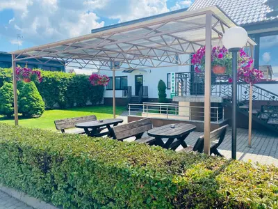 a picnic area with benches and a pavilion with flowers at Olympus Hotel in Kaunas