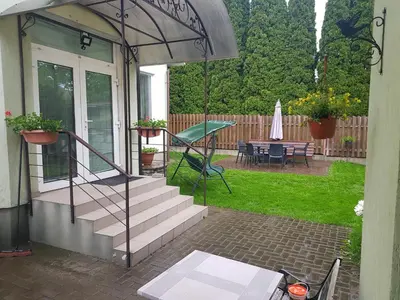 a house with a patio with a table and an umbrella at Zveryno guest house in Vilnius