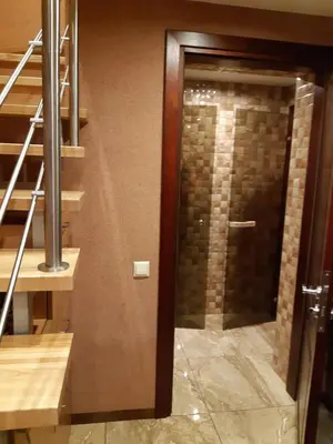 a glass door in a room with a staircase at Zveryno guest house in Vilnius