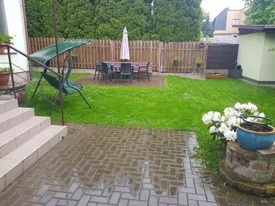 a patio with a table and a chair in a yard at Zveryno guest house in Vilnius