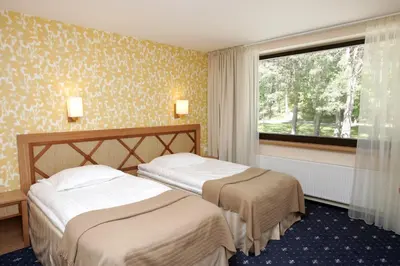 two beds in a hotel room with a window at Park Villa Hotel in Vilnius