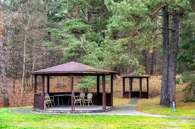 a gazebo with chairs and a table in a park at Park Villa Hotel in Vilnius