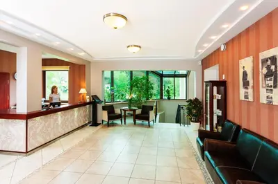 a hotel lobby with a woman sitting at a counter at Park Villa Hotel in Vilnius