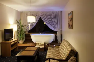 a room with a bath tub and a room with a television at Park Villa Hotel in Vilnius