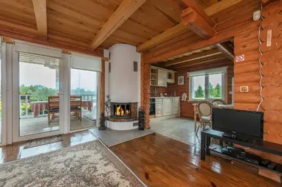 a living room with a fireplace and a dining room at Vila Terra Resort in Girsteitiškis